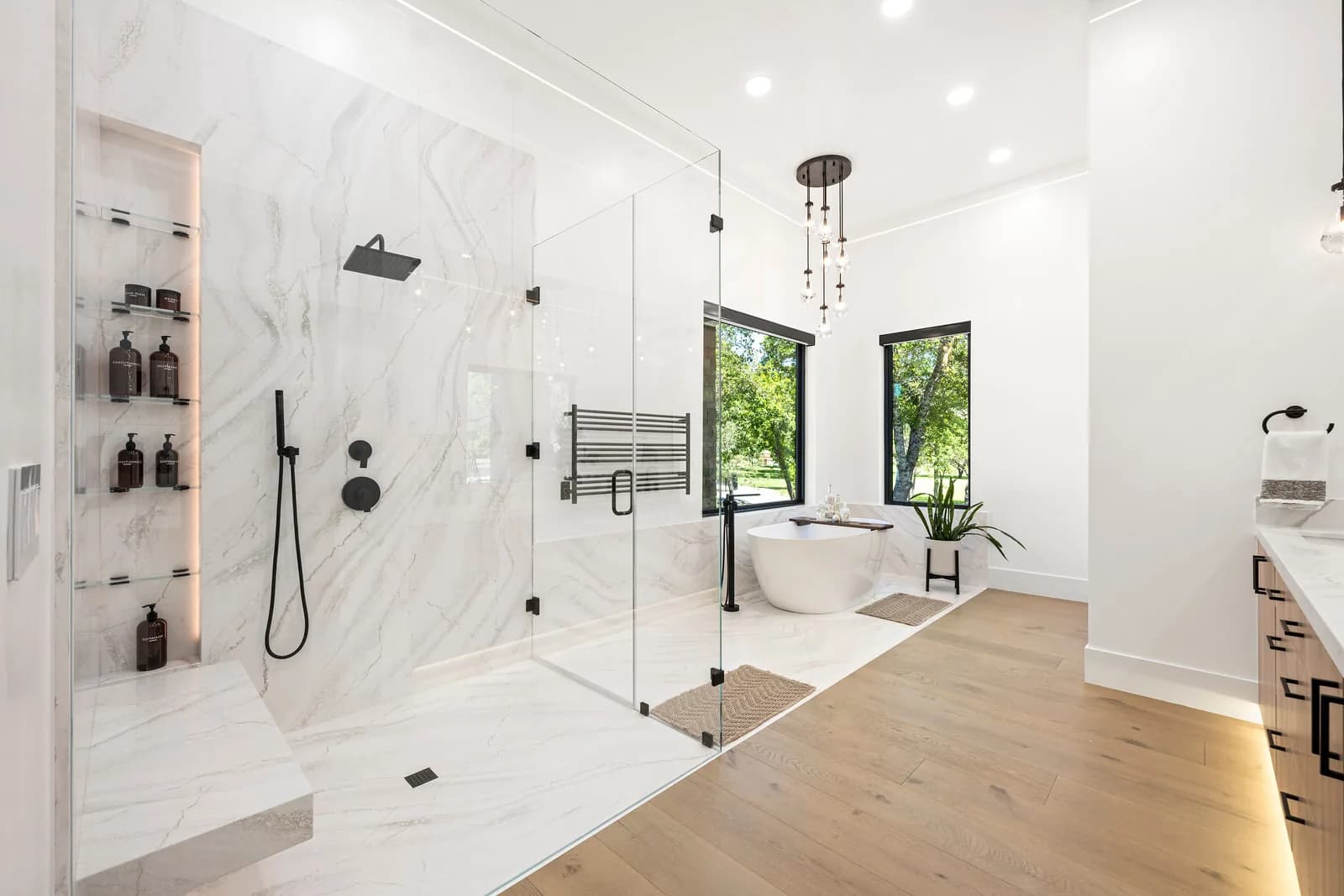Finished white marble bathroom with glass walk-in shower delivered by a bathroom remodeling company that ranked first in local search after a nine-month SEO campaign